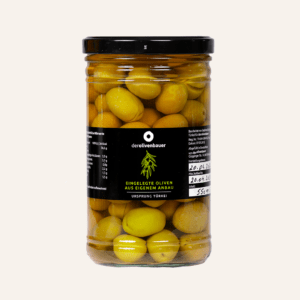 Grüne Oliven mit Stein im kleinen Glas.